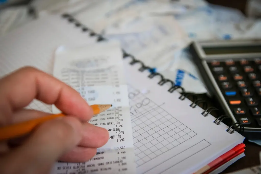 Calculating expenses with a notebook and calculator